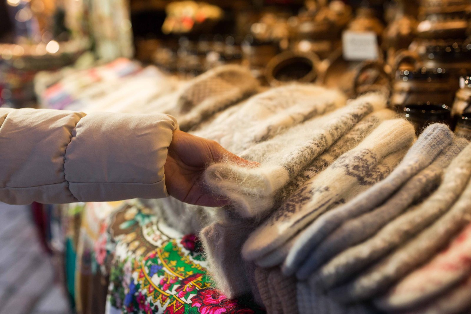 woman buying woolen mittens at christmas market