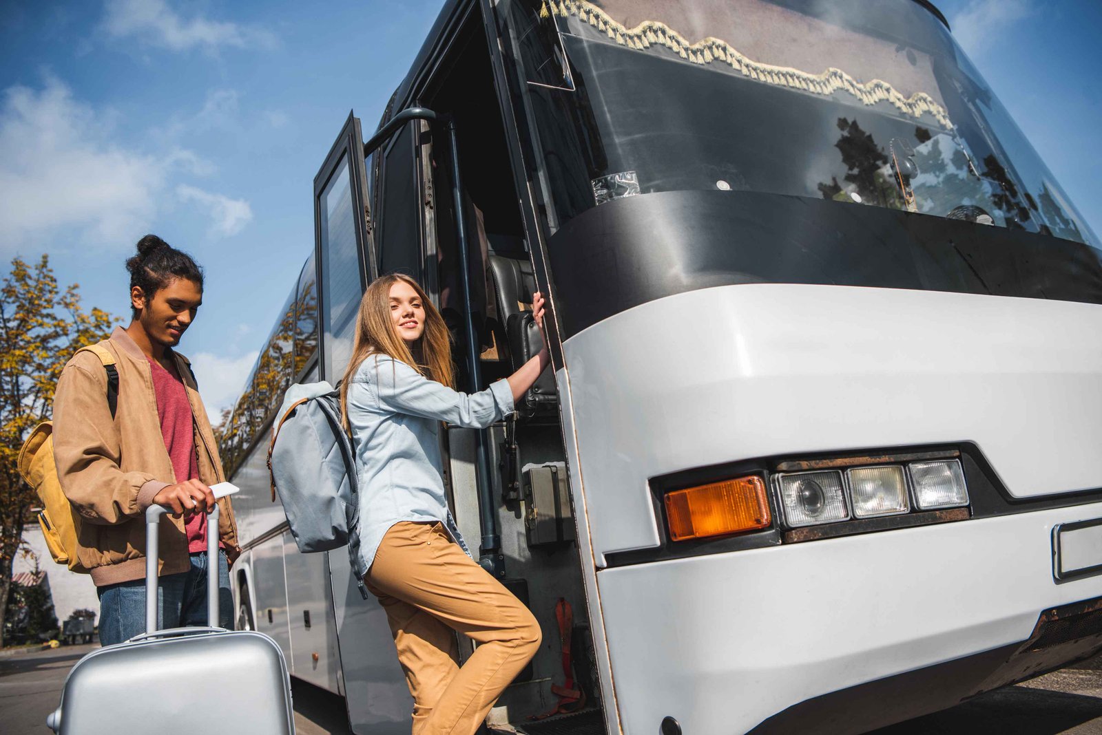 friends boarding tour bus for vacation travel
